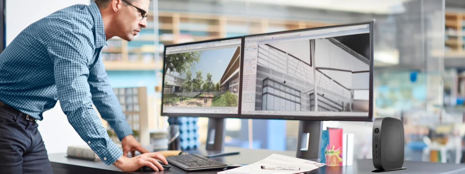 Man standing over a computer workstation