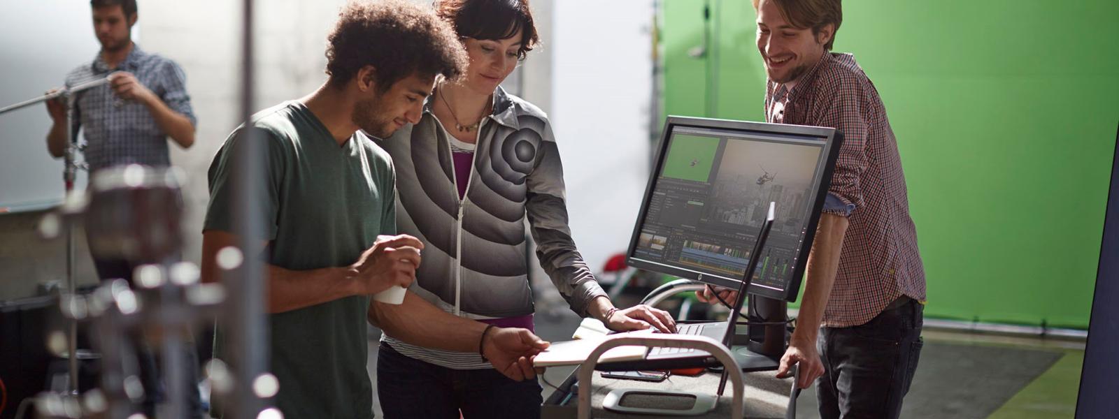 Group of people gathered around a computer