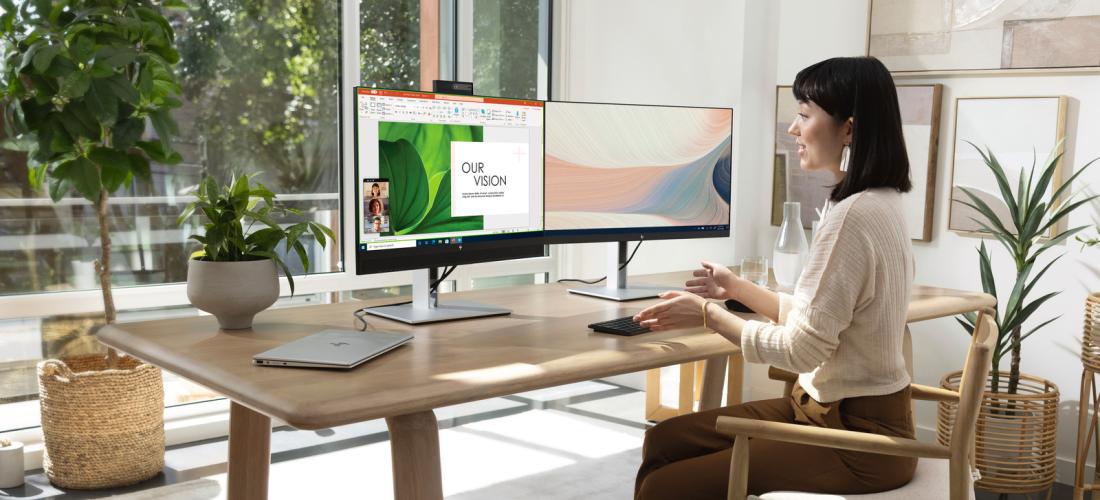 Woman working on a multiple monitor desktop setup