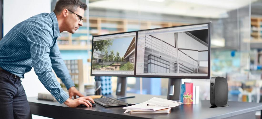 Man standing over a computer workstation