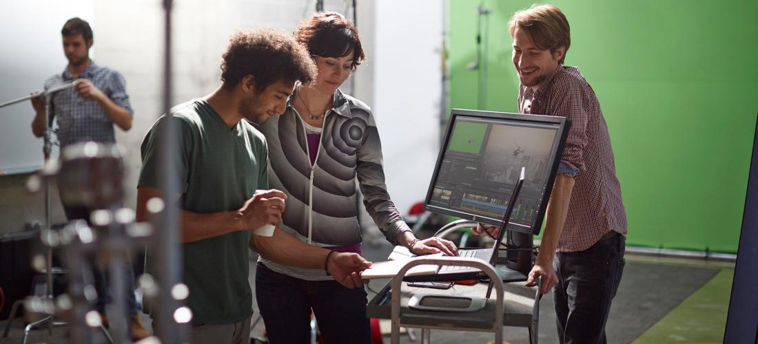 Group of people gathered around a computer